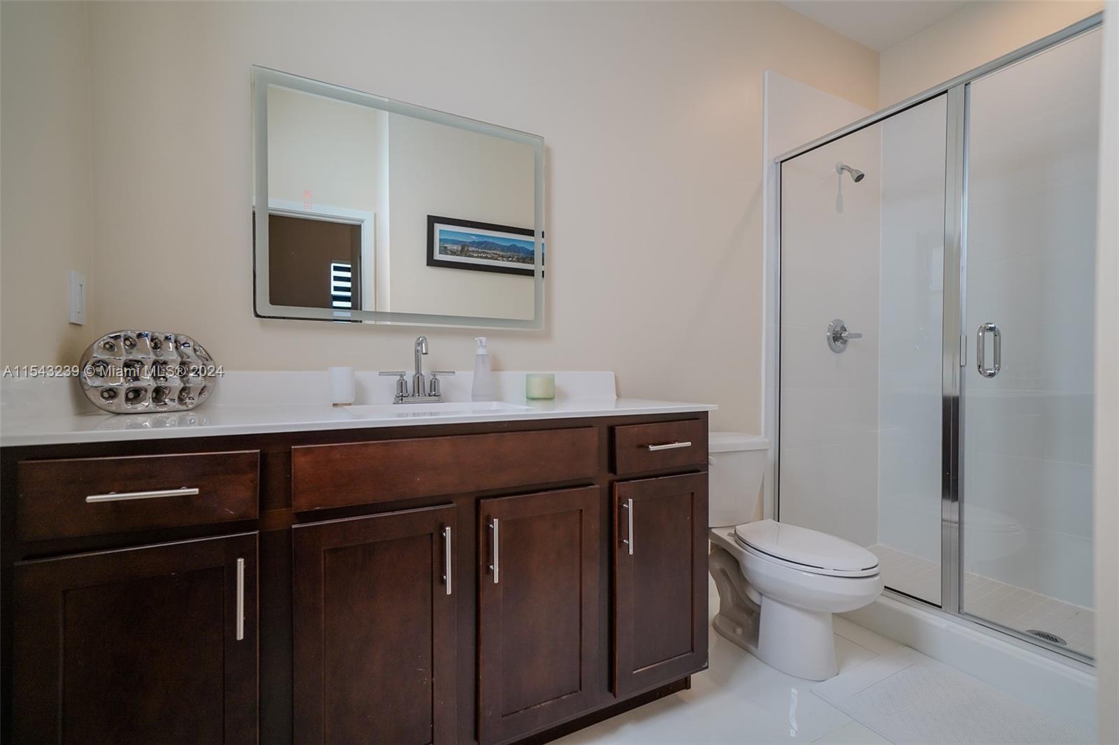 14570 Southwest 19th Street Miami, FL 33175 - Photo 21 of 30 a bathroom with a sink a toilet a mirror and shower