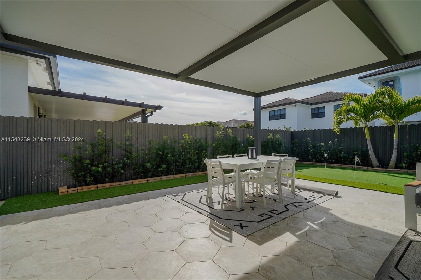 14570 Southwest 19th Street Miami, FL 33175 - Photo 23 of 30 a view of a patio with table and chairs potted plants and floor to ceiling window