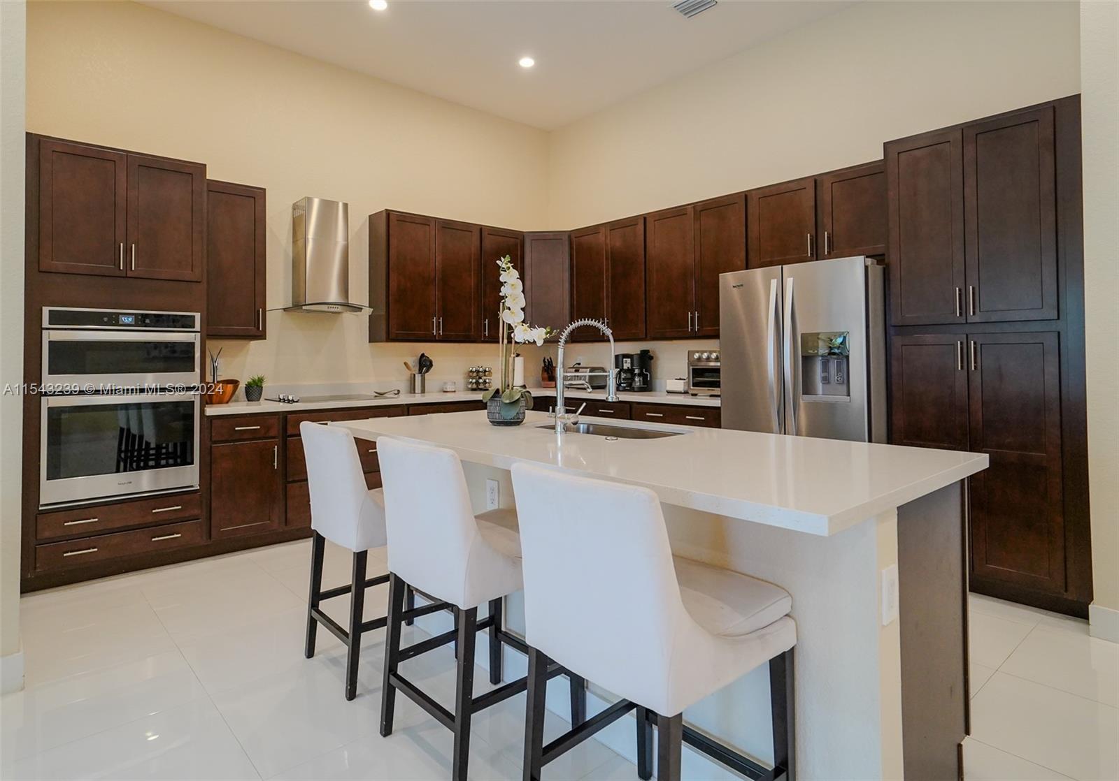 14570 Southwest 19th Street Miami, FL 33175 - Photo 4 of 30 a kitchen with stainless steel appliances a table chairs refrigerator and microwave