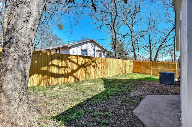 a view of a yard with wooden fence