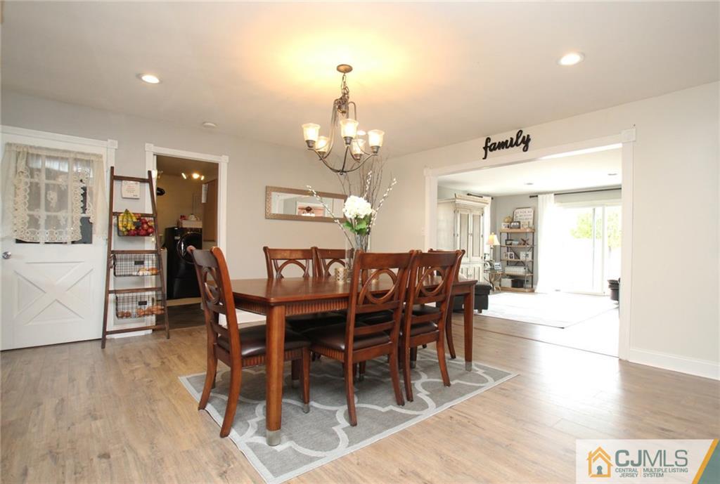 16 Ridge Road Old Bridge, NJ 08857 - Photo 7 of 22 a dining room with wooden floor a chandelier a wooden table and chairs