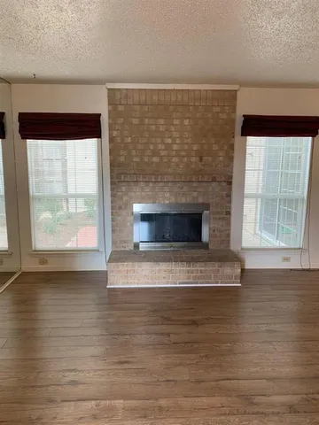 a view of empty room with wooden floor and fireplace
