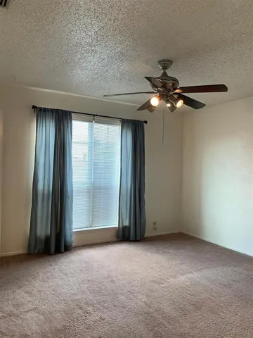 an empty room with chandelier fan