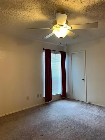 a view of an empty room with a chandelier fan