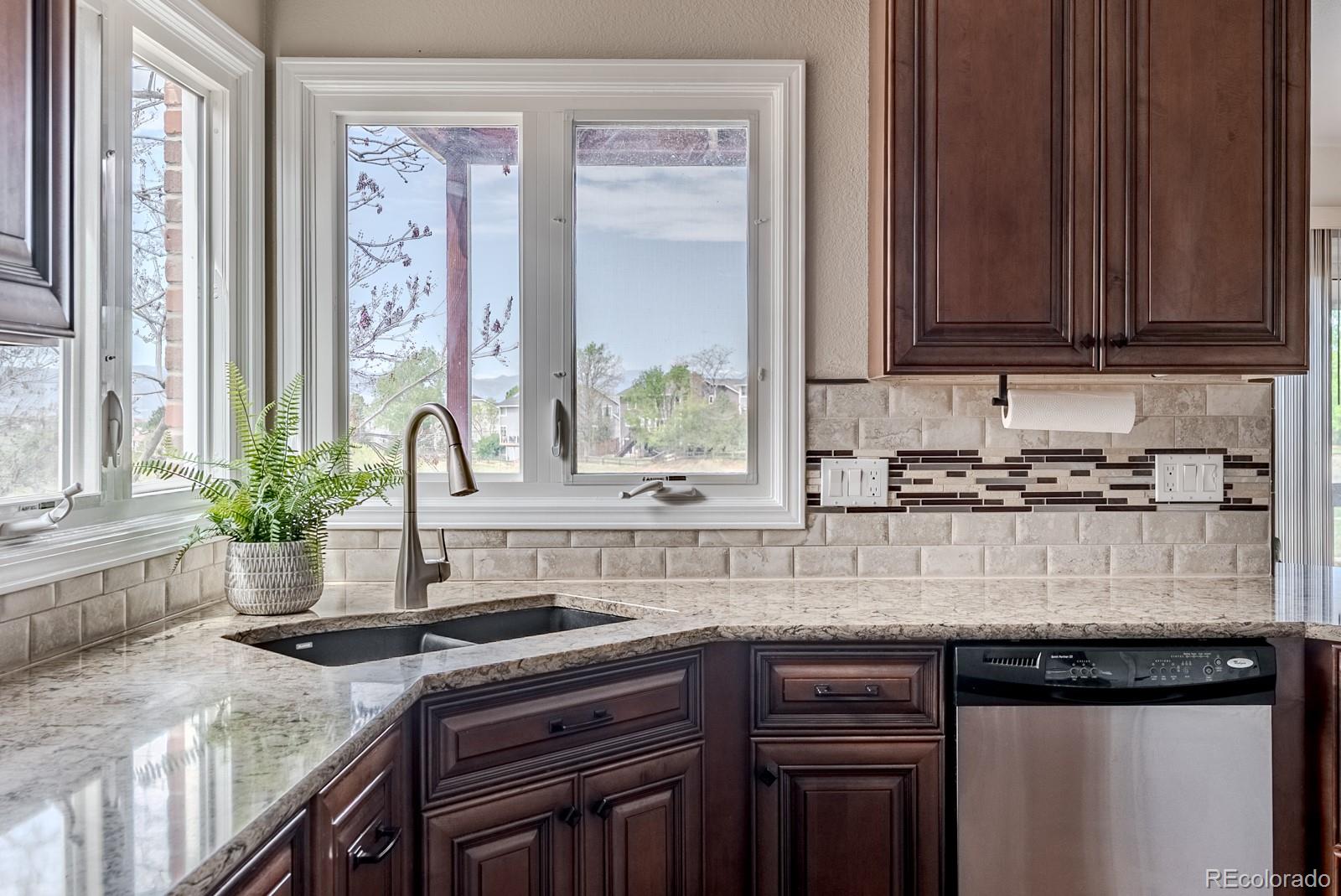 1914 Terrace Drive Highlands Ranch, CO 80126 - Photo 10 of 47 a kitchen with stainless steel appliances granite countertop a stove a sink and a microwave