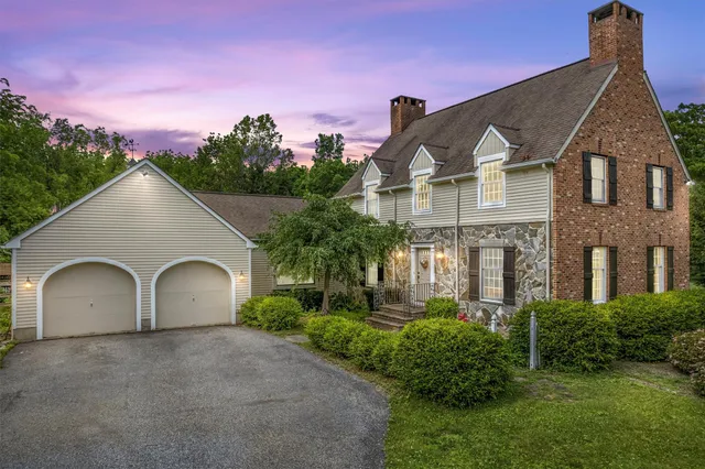 a view of a big house with a yard and plants