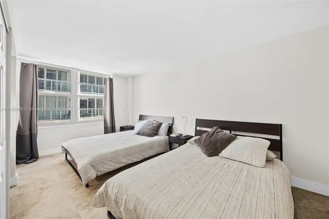 a bedroom with two beds and a large window