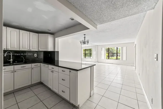 a kitchen with white cabinets a sink dishwasher and a stove top oven