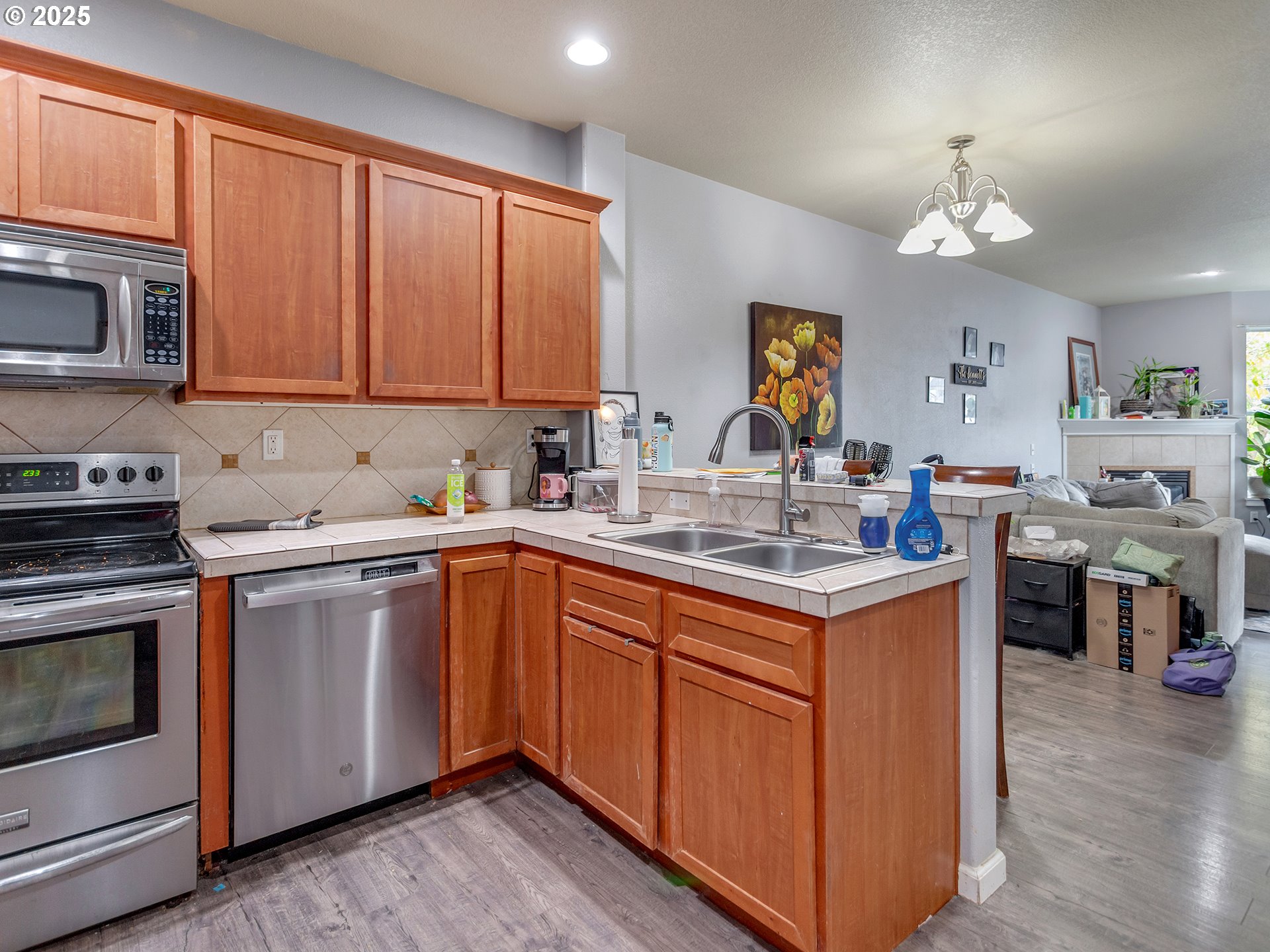 7817 Southwest Brookline Lane Portland, OR 97224 - Photo 12 of 13 a kitchen with stainless steel appliances granite countertop a stove a sink dishwasher and a microwave oven with wooden floor