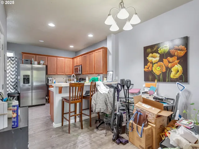 a view of a dining room with furniture a chandelier and a window