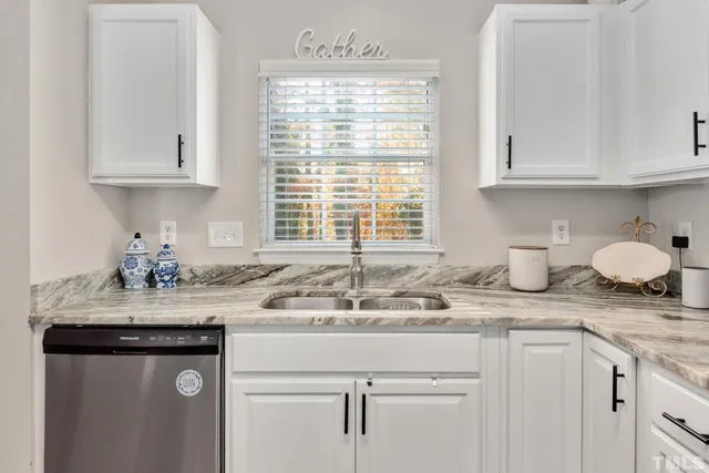 a kitchen with granite countertop white cabinets and white appliances