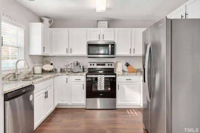 a kitchen with stainless steel appliances granite countertop a refrigerator stove a sink and a microwave