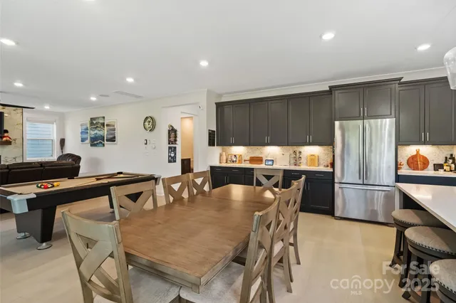 a kitchen with granite countertop a table chairs stove and cabinets
