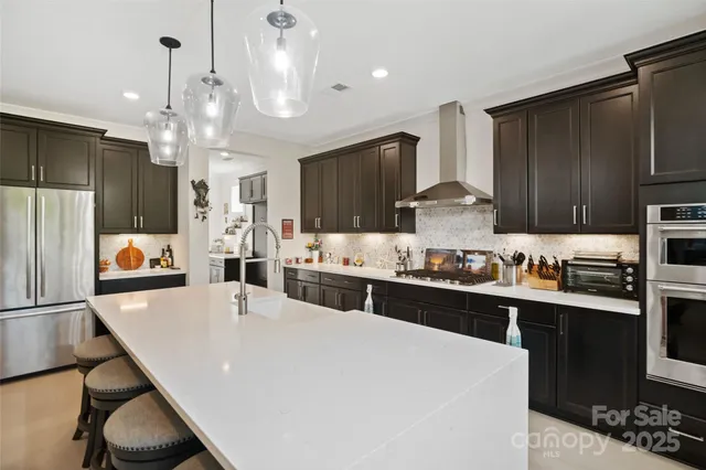a large kitchen with kitchen island a sink stove and refrigerator