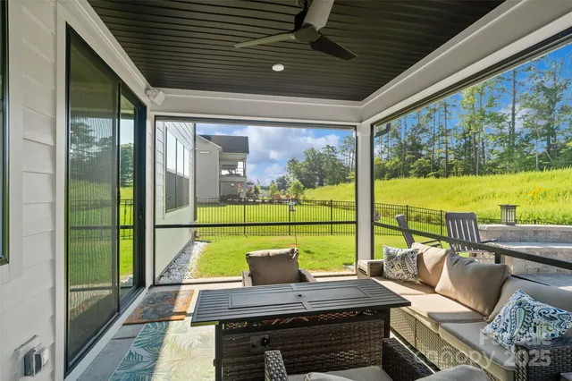 a view of swimming pool with lawn chairs and plants
