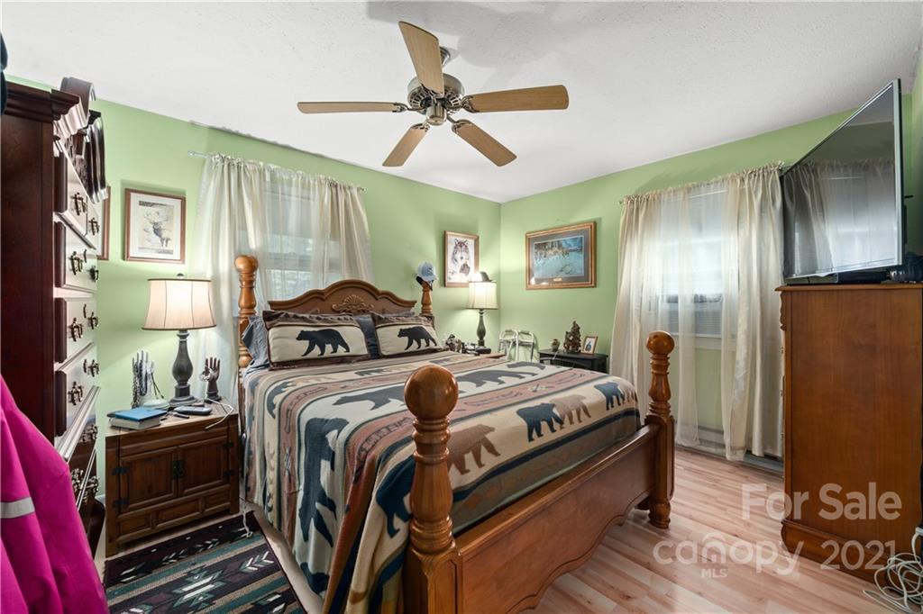 165 Nottingham Road Maggie Valley, NC 28751 - Photo 22 of 29 a bedroom with bed and a chandelier
