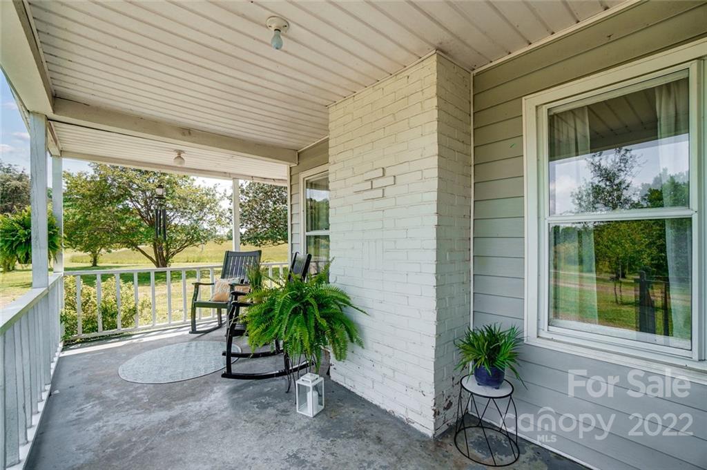 715 Clontz Long Road Monroe, NC 28110 - Photo 4 of 34 a porch with chairs and potted plants