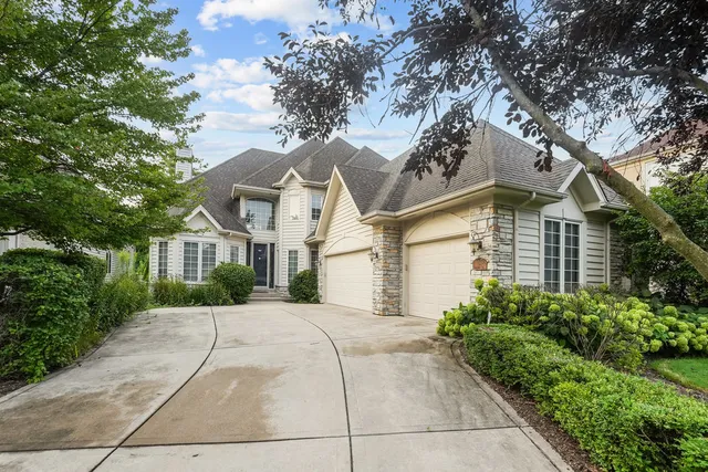 a front view of a house with yard and trees