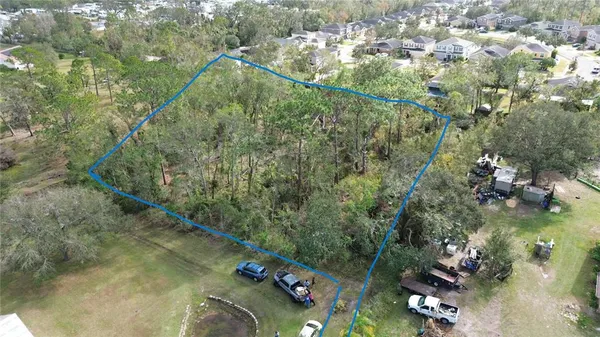 an aerial view of residential houses with green space and trees