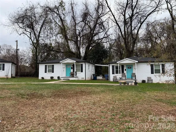 a front view of a house with a yard and trees