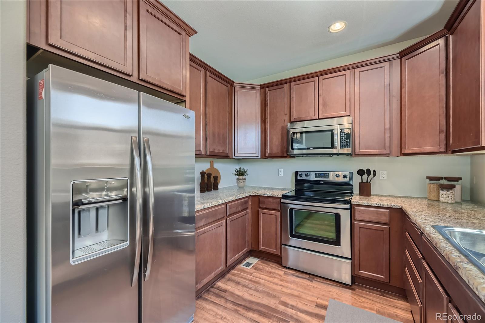 9494 Halstead Lane Lone Tree, CO 80124 - Photo 8 of 23 a kitchen with stainless steel appliances granite countertop a refrigerator a stove top oven a sink and dishwasher