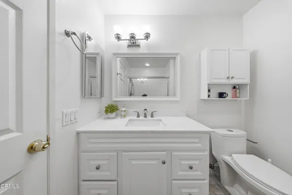 a bathroom with a sink vanity mirror and toilet