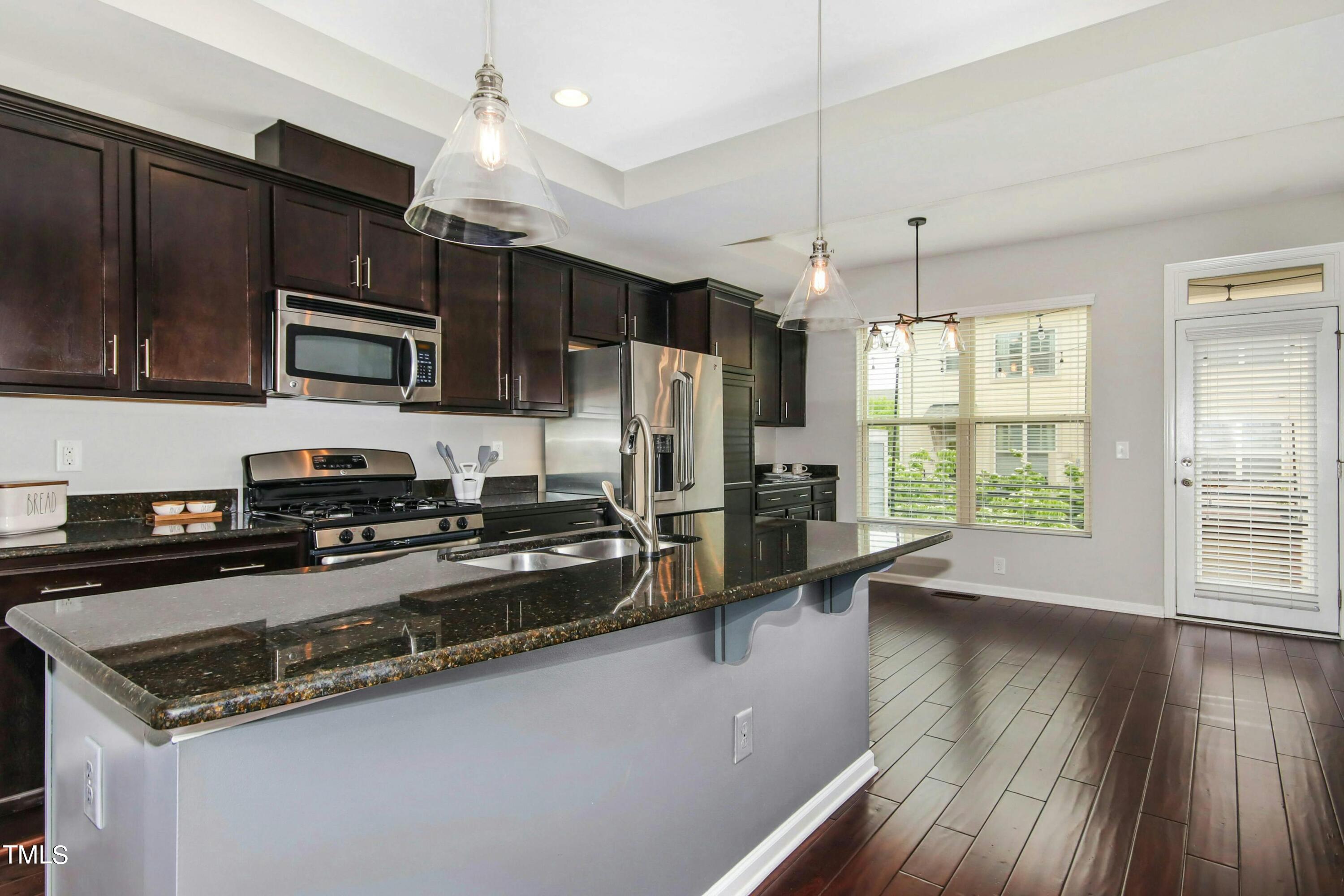 1418 Ardara Lane Raleigh, NC 27607 - Photo 12 of 34 a kitchen with granite countertop a stove sink and microwave
