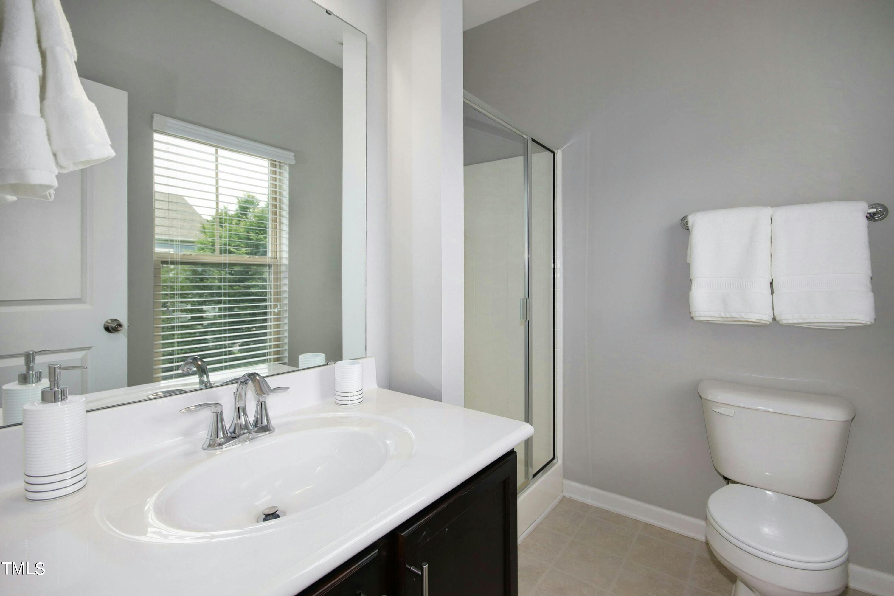 1418 Ardara Lane Raleigh, NC 27607 - Photo 25 of 34 a bathroom with a sink a toilet and mirror