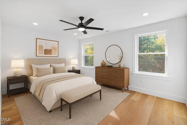 a spacious bedroom with a bed a window and a chandelier
