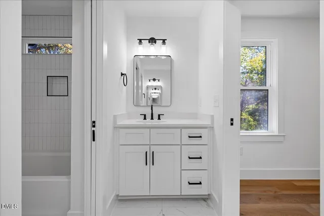 a bathroom with a sink a mirror and a window