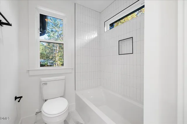 a white toilet sitting next to a bath tub