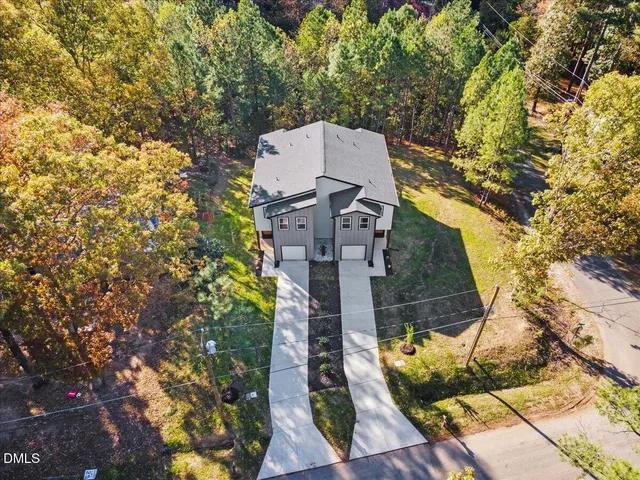 an aerial view of residential house with outdoor space and trees all around