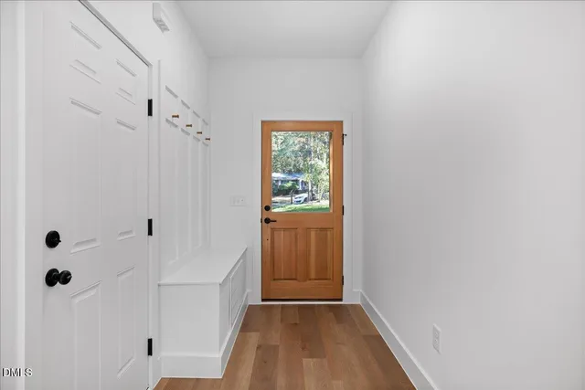 a view of a hallway with wooden floor and closet