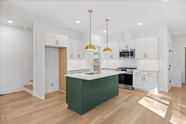 a kitchen with stainless steel appliances granite countertop a sink stove and refrigerator