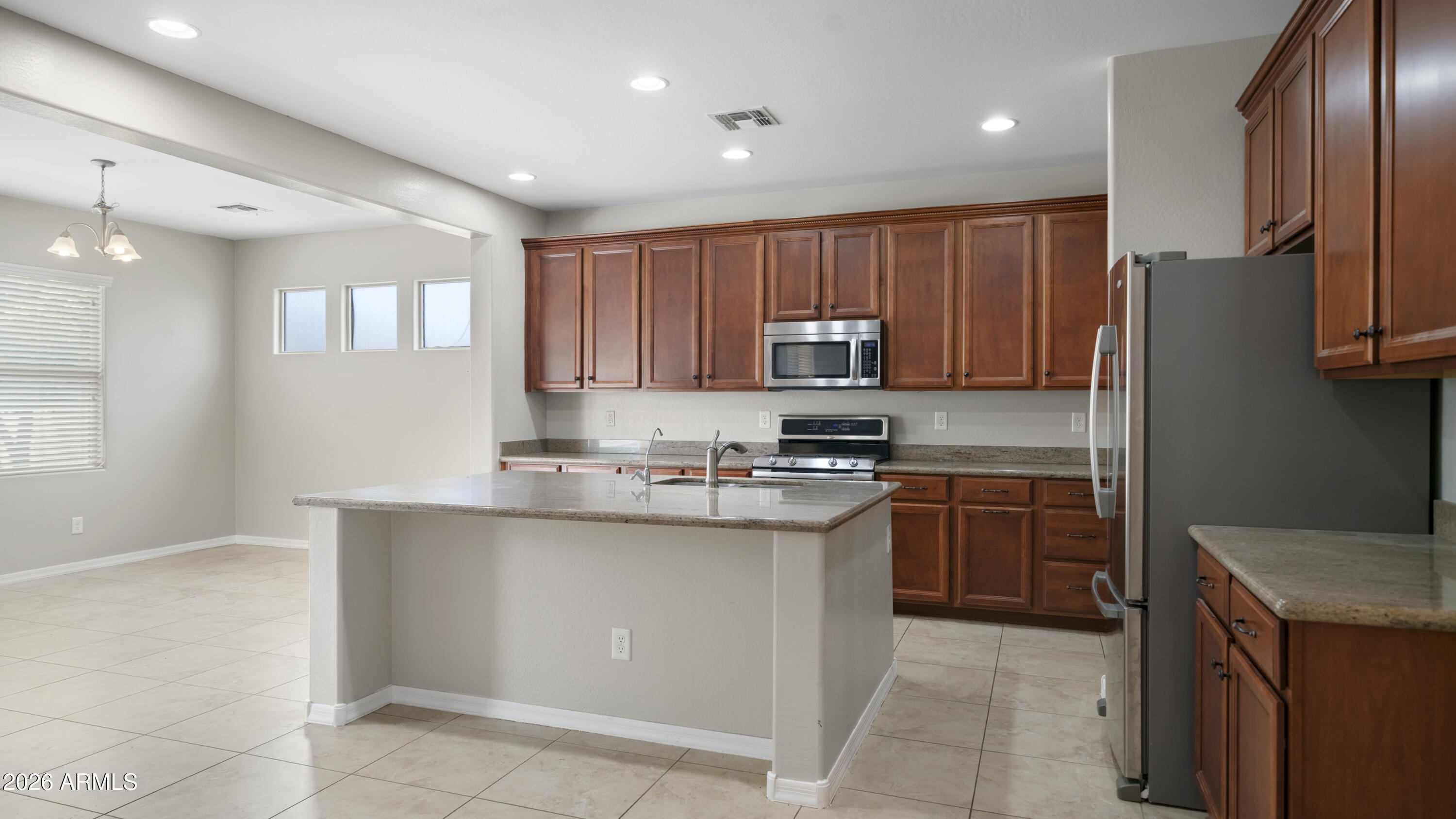 16159 West Granada Road Goodyear, AZ 85395 - Photo 13 of 41 a kitchen with stainless steel appliances granite countertop a refrigerator sink and cabinets