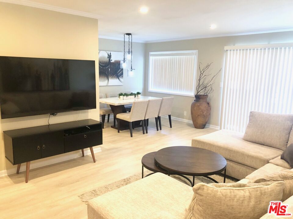 1250 North Kings Road, Unit 506 West Hollywood, CA 90069 - Photo 1 of 22 a living room with furniture a flat screen tv and a large window