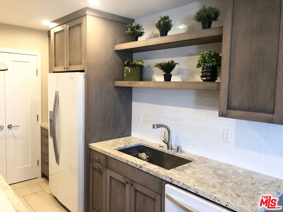 1250 North Kings Road, Unit 506 West Hollywood, CA 90069 - Photo 9 of 22 a kitchen with stainless steel appliances granite countertop a refrigerator and a sink