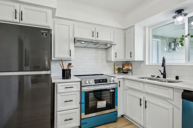 a kitchen with white cabinets and appliances