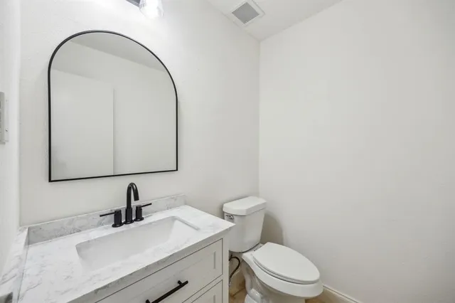 a bathroom with a sink a toilet and mirror