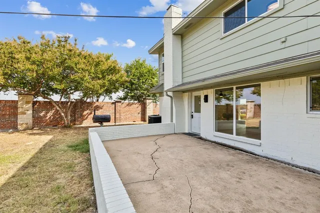 a view of a house with a yard and large tree