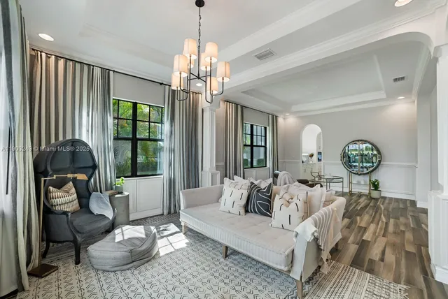 a living room with furniture a chandelier and a window