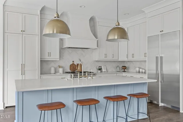 a kitchen with white cabinets and appliances