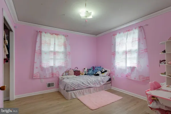 a bedroom with pink walls and pink window