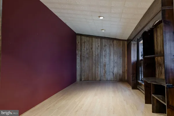 an empty room with wooden floor and closet