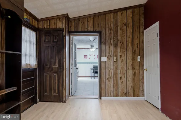 a kitchen with stainless steel appliances kitchen island granite countertop a refrigerator a stove a sink a dining table and chairs with wooden floor