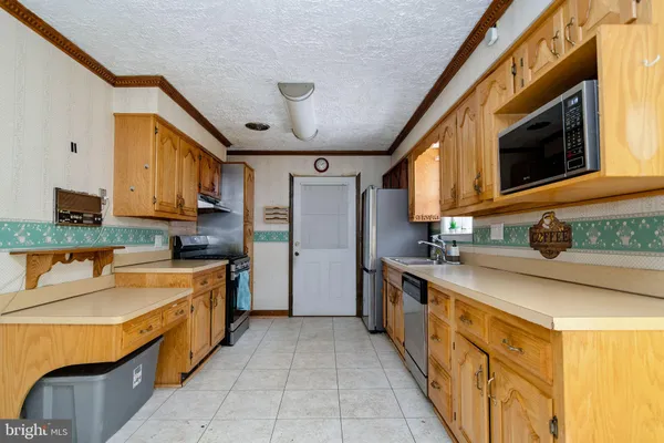 a large kitchen with stainless steel appliances granite countertop a sink and cabinets