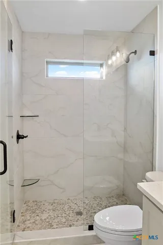 a bathroom with a toilet and a shower