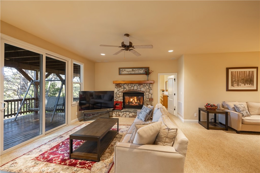 173 Grizzly Road Lake Arrowhead, CA 92352 - Photo 19 of 40 a living room with furniture a fireplace and a table
