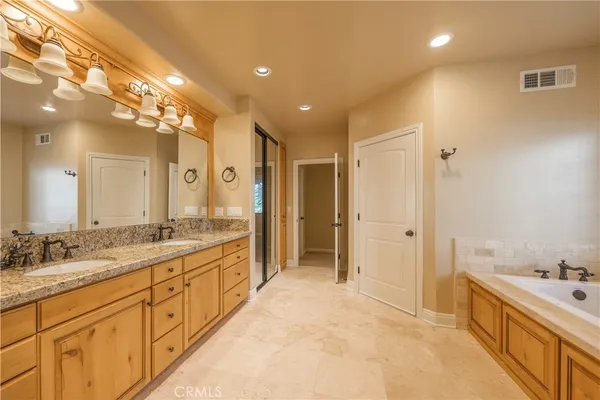 a spacious bathroom with a double vanity sink a large mirror and a shower