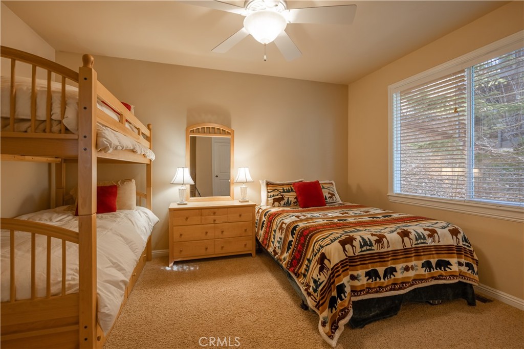 173 Grizzly Road Lake Arrowhead, CA 92352 - Photo 34 of 40 a bedroom with a bed and a chandelier